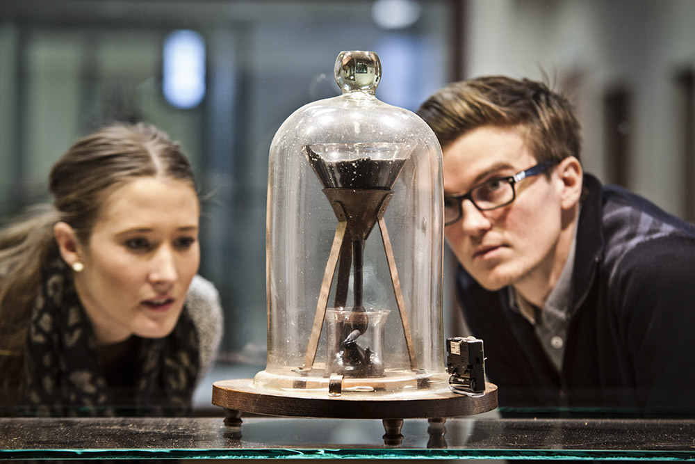PhD students inspect the Pitch Drop experiment.